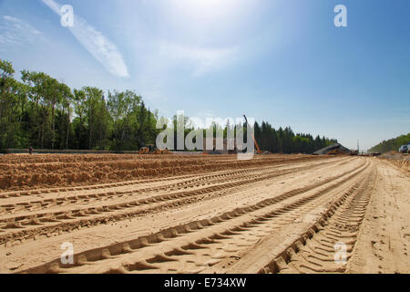 Bulldozer tracce sulla sabbia durante la costruzione della strada Foto Stock