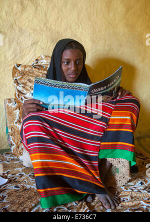 Mahammed Fatouma dall etnia afar la lettura di un libro di scuola, Afambo, Etiopia Foto Stock