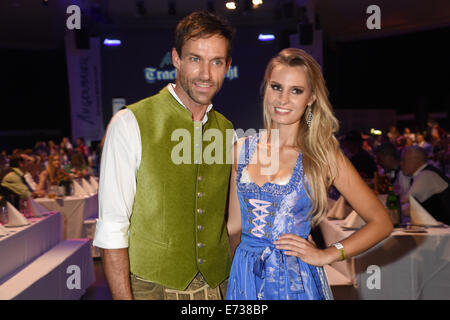 Ex ponticello sci Sven Hannawald (L) pone con i cosiddetti Wiesnplaymate, Doreen Seidel, durante il tradizionale costume notte a Postpalast a Monaco di Baviera, Germania, il 4 settembre 2014. Il tradizionale produttore di abbigliamento "Trachten Angermaier" ha presentato le ultime tendenze della moda in abbigliamento tradizionale nella corsa fino al 'Oktoberfest' del festival della birra di Monaco di Baviera, che inizia il 20 settembre 2014. Foto: Felix Hoerhager/dpa Foto Stock