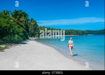 Donna che cammina su una spiaggia di sabbia bianca, Il Nanuya Lailai island, la Blue Lagoon, Yasawas, Figi, South Pacific Pacific Foto Stock