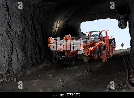 Perforare il carro di perforazione che scende nella miniera di platino dal portale di ingresso dell'albero della rampa prima di praticare fori di scoppio nella roccia per il nuovo tunnel di manutenzione Foto Stock