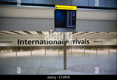 Inghilterra, London, Aereoporto di Heathrow, deserte International hall degli arrivi con elettronica di bordo arrivi elenco dei voli in arrivo. Foto Stock