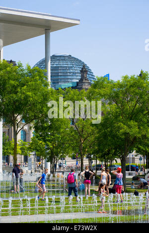 Germania, Berlino Mitte, persone il raffreddamento in acqua delle fontane di fronte al Paolo Loebe Haus dall architetto Stephan Braunfels Foto Stock