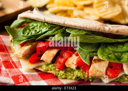 Un sano pollo grigliato Pesto Flatbread Sandwich con peperoni e spinaci Foto Stock