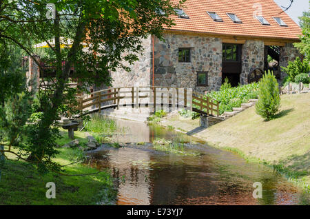 Parco paesaggio con ponte in legno sul torrente e architettonici antichi mattoni manor Foto Stock