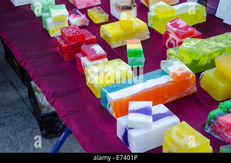 Multicolore naturale sapone artigianale tablet con erbe medicinali venduti nel mercato all'aperto. Autunno Fiera della città. I clienti che acquistano beni. Foto Stock