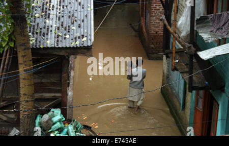 Srinagar, Indiano Kashmir amministrato6th sett, 2014: un bambino è sollevato dal padre sulle sue spalle come loro modo strade allagate il pedaggio a 100 nelle peggiori inondazioni nello stato in quasi sei decenni. Sette persone sono morte in due diversi incidenti di una casa di collassare a causa di frana provocata dalle forti piogge nel distretto di Udhampur e altri quattro corpi sono stati ritrovati nel distretto di Rajouri, un membro ufficiale del governo detto.(Sofi Suhail/Alamy Live News ) Foto Stock