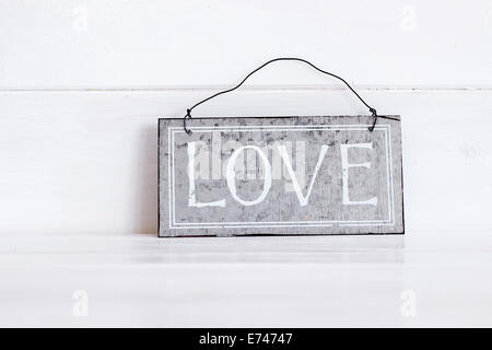 Amore parola scritta su una piastra di sfondo di legno Foto Stock