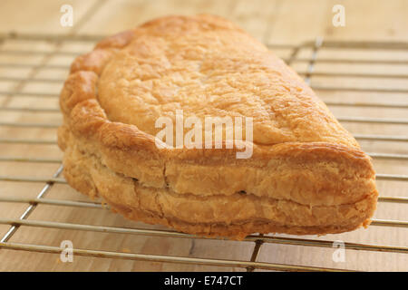 Fresco cotto al forno tradizionale Cornish pasty raffreddamento su un rack Foto Stock