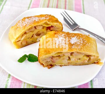 Strudel di pere in una piastra bianca con una forcella su una tovaglia di lino sfondo Foto Stock