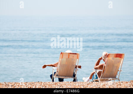 Due anziani a prendere il sole in sedie da scrivania Foto Stock