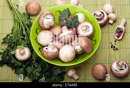 Pulsante o Champignon e Portabello funghi in vaso verde con prezzemolo e pepe misto fagioli. Foto Stock