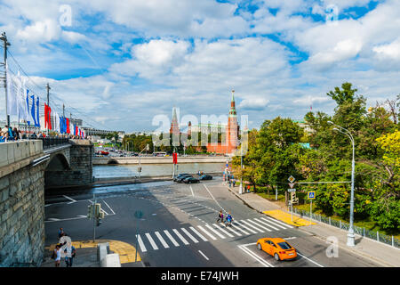 Mosca, Russia. Sabato 7 settembre 6, 2014. La città di Mosca giorno viene celebrato ogni anno nel primo sabato di settembre. La città è stata fondata nel 1147 dal principe Yuri Dolgorukiy (Long-consegnato). Questo anno la città celebra 867th compleanno. Persone attraversano grande ponte in pietra, decorata con bandiere, nella direzione del Cremlino di Mosca (in background). Credito: Alex Immagini/Alamy Live News Foto Stock