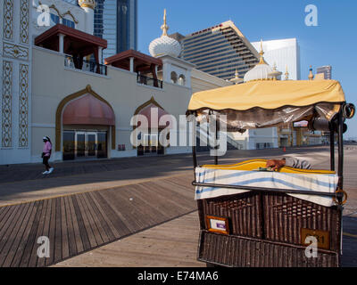 Una sedia di rotolamento operatore attende i turisti su Atlantic City boardwalk Foto Stock