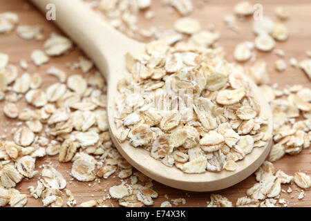 Fiocchi d'avena in il cucchiaio di legno. Close-up. Foto Stock