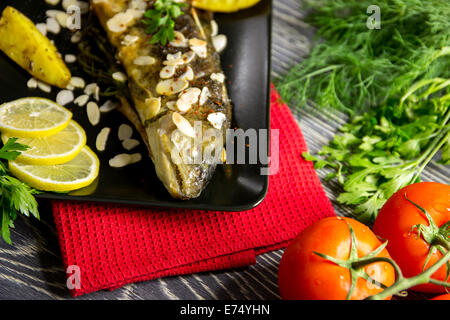 Trota fritta con mandorle, aneto e Spicchi di patate Foto Stock