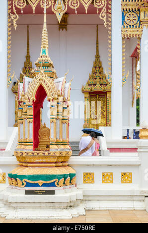 Un paio di riparo sotto un ombrello di Wat Karon in Karon, Isola di Phuket, Tailandia Foto Stock