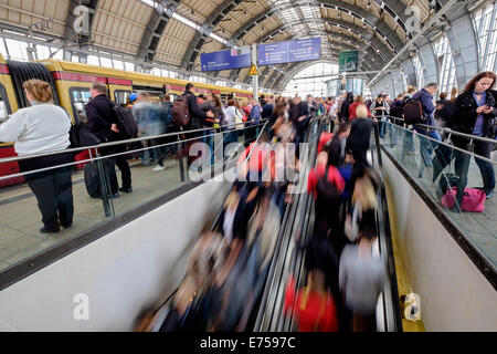 Sfocata immagine di movimento di passeggeri su piattaforme a stazione ferroviaria Alexanderplatz con la S-Bahn a Berlino Germania Foto Stock