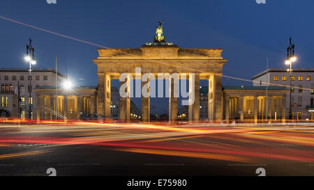 Vista serale della Porta di Brandeburgo con percorsi di movimento del traffico su strada nel quartiere Mitte Berlino Germania Foto Stock