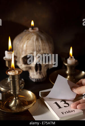 Venerdì 13 su un calendario con candele e un creepy cranio Foto Stock