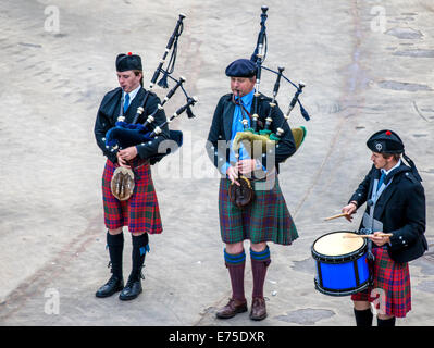 Una banda scozzese agisce come host all'arrivo dei transatlantici nel porto di Invergordon in Scozia comitato. Foto Stock
