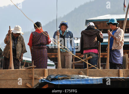 Donne locali contribuendo a costruire una nuova casa, Punakha, Bhutan Foto Stock