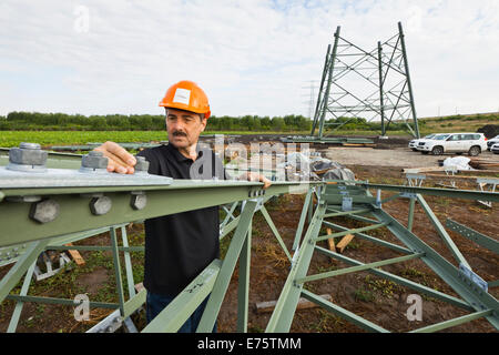 Il controllo tecnico di collegamenti a vite su segmenti di alta tensione tralicci di 380 kV extra-linea elettrica ad alta tensione sotto Foto Stock