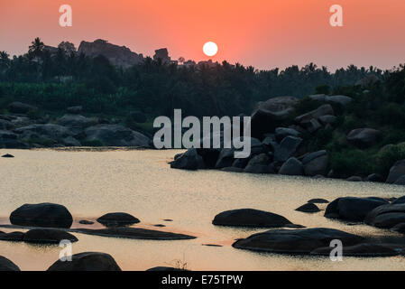 Tramonto sul fiume Tungabhadra e una parte delle rovine dell' ex impero Vijayanagara, Hampi, Karnataka, India Foto Stock