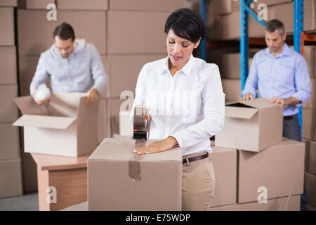 Gli addetti al magazzino di imballare scatole Foto Stock