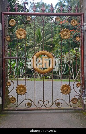 Cancello con svastica, simbolo di buona fortuna nell'Induismo, a Tirta Empul acqua tempio, Bali, Indonesia Foto Stock