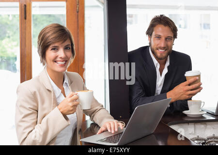 La gente di affari di sorridere alla telecamera Foto Stock