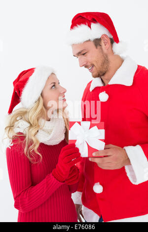 Attraente coppia giovane indossando cappelli di Babbo Natale con il dono Foto Stock