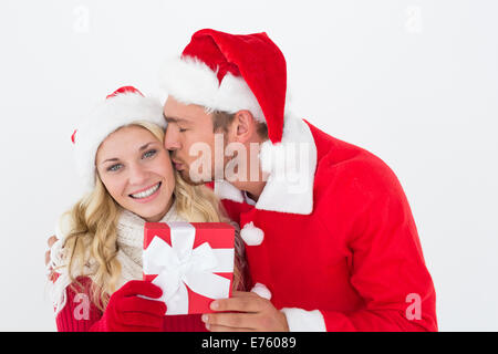 Attraente coppia giovane indossando cappelli di Babbo Natale con il dono Foto Stock