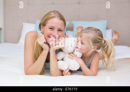 Carino bambina e madre sul letto Foto Stock