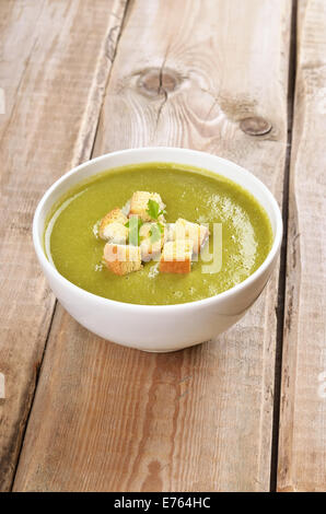 Zuppa di spinaci con croste essiccato su tavola in legno rustico Foto Stock