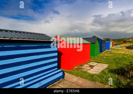 Chalet in spiaggia HOPEMAN MORAY cielo blu e nuvole temporalesche su RIGHE DI MULTI capanne colorate Foto Stock