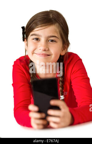 Carino bambina utilizza lo smartphone Foto Stock