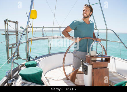 Uomo in barca a vela dello sterzo sull'acqua Foto Stock