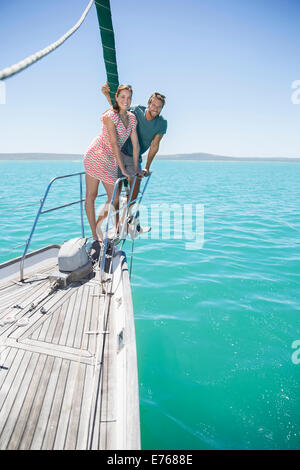 Matura in piedi sulla parte anteriore della barca a vela Foto Stock