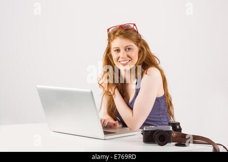 Pretty redhead lavorando sul computer portatile Foto Stock