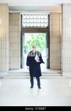 Giudice in piedi di fronte a porte a courthouse Foto Stock