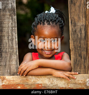 Close up ritratto della bella giovane Africana appoggiata sulla staccionata in legno all'esterno. Foto Stock