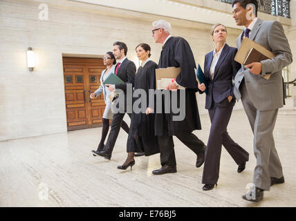 I giudici e gli avvocati a piedi attraverso courthouse insieme Foto Stock