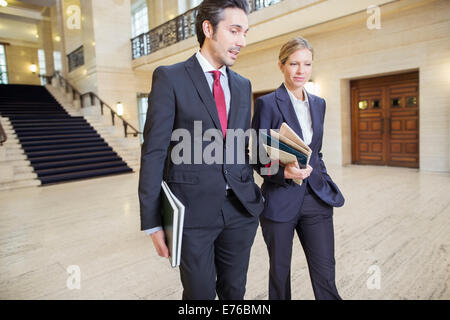 Gli avvocati a piedi attraverso courthouse insieme Foto Stock