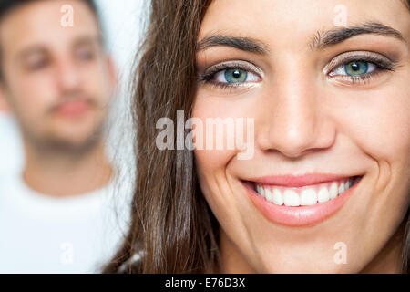 Close up ritratto del viso della ragazza attraente con sorriso toothy e ragazzo in background. Foto Stock