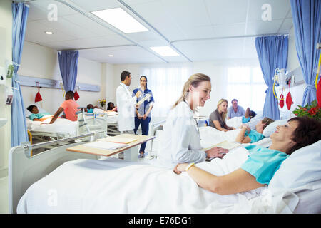 I medici, gli infermieri e i pazienti nella stanza di ospedale Foto Stock