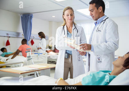 I medici a parlare con il paziente nella stanza di ospedale Foto Stock