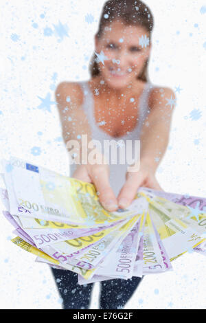 Immagine composita del ritratto di una donna felice che mostra di banconote Foto Stock