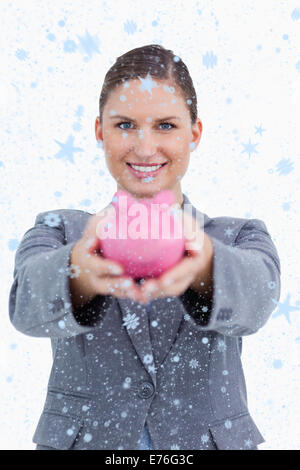 Immagine composita di sorridere impiegato di banca che offre salvadanaio Foto Stock