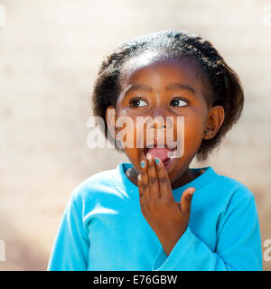 Close up ritratto di poco ragazza africana con sorpresa di fronte l'espressione. Foto Stock